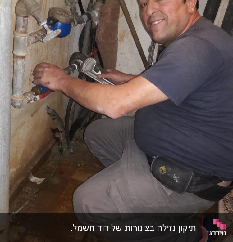 אדם עובד על צינורות עם מפתח צינורות